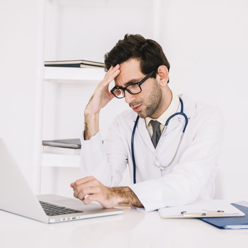 Physician looking tired with laptop